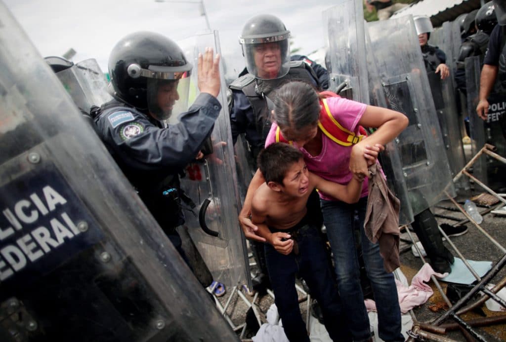 Migrantes se enfrentan con granaderos en la frontera México-Guatemala.